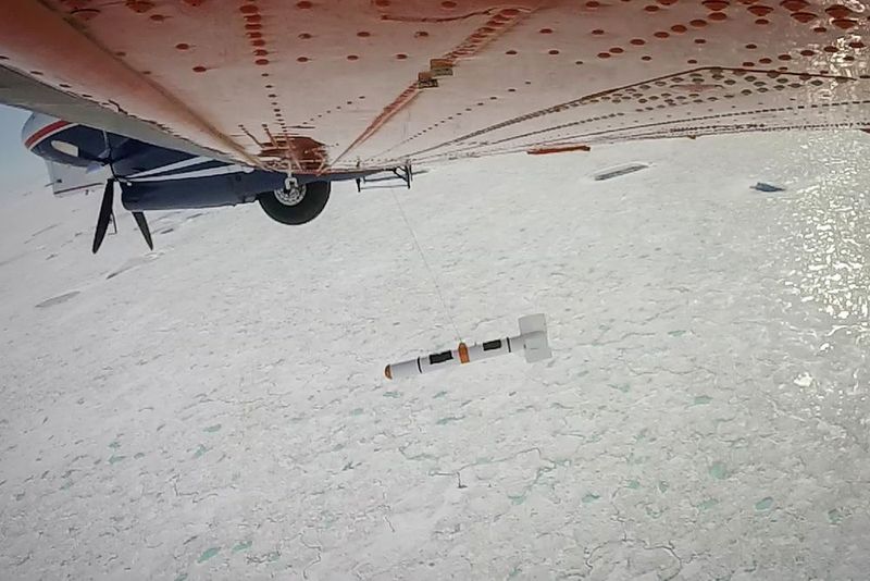 Meereisdickenmessungen mit dem AWI-Forschungsflugzeug Polar 6 nördlich Grönlands, August 2016. Von Bord des Flugzeuges aus bedienen die Meereisphysiker eine Winde, welche das torpedoförmige Messgerät in die Tiefe hinabsinken lässt. (Alfred-Wegener-Institut / Esther Horvath)