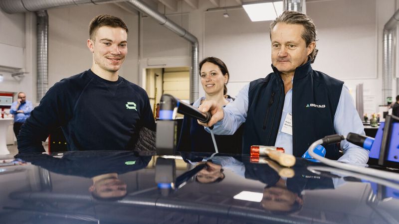 Eher kleinteilig ging es am Stand von Betag Innovation/Beulentechnik AG zu: Inhaber Ralph Meichtry (rechts) zeigte und erklärte die thermische Rückverformung von Hagel- und Parkdellen. (Bild: Stefan Bausewein)