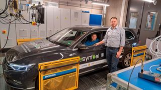 Im Auto sitzt Kfz-Techniker Florian Knoch, Kfz-Ingenieur Steffen Krajewski steht daneben: An der Hochschule Coburg führen sie die Tests auf dem Rollenprüfstand durch. (Bild: Anja Singer/ Hochschule Coburg)