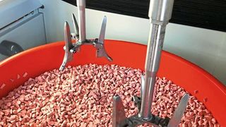 Die Hüftschäfte werden an einer eigens konstruierten Spannvorrichtung befestigt, die für unterschiedliche Schafttypen und –größen verwendet werden kann. Im ersten Schritt kommt für das Nassschleifen ein Gemisch aus kunststoffgebundenen Schleifkörpern mit abgestimmtem Compound zum Einsatz. (Rösler Oberflächentechnik GmbH)