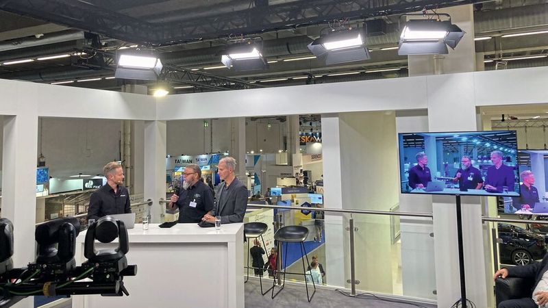 Im Werkstattbereich des ZDK-Stands geht es um die E-Kompetenz der Betriebe. Moderator ist Philipp Sternberg von Fabucar (l.) spricht mit Michael Dittmar (Mitte), Dittmar und Stachowiak GmbH .  (Bild: ZDK)