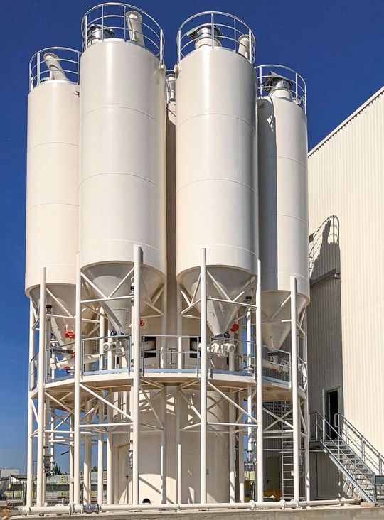 Durch eine konzentrische Anordnung können viele Komponenten der Anlage von mehreren Silos gemeinschaftlich verwendet werden. Durch eine konzentrische Anordnung können viele Komponenten der Anlage von mehreren Silos gemeinschaftlich verwendet werden.
