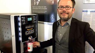 Stefan Göbel am von ihm vertriebenen Kaffeeautomaten. (Faust / »kfz-betrieb«)