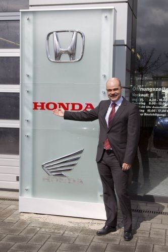 Lars Zeiler, Leiter der Händlernetzentwicklung bei Honda Deutschland, vor der neuen Honda-Signalisation aus Glas. (Foto: Honda)