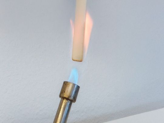 Hier wird an einem typischen Probekörper aus biobasiertem Hochleistungs-Kunststoff der Brennbarkeitstest am Fraunhofer Umsicht vorgenommen. Es handelt sich um eine Alternative aus Polymilchsäure (PLA), die mehr Nachhaltigkeit in den Elektronik- und Elektrosektor bringen kann.(Bild:  Umsicht)