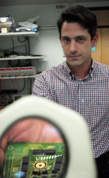 IBM-Forscher Nikolaos Papandreou demonstriert den Phasenwechselspeicher unter einem Vergrößerungsglas in seinem Labor. (Bild: IBM Research)