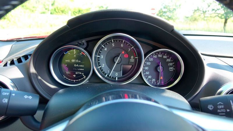 5. Das Cockpit: Über Mazdas Eigenständigkeit beim Thema Cockpitgestaltung und Bedienung haben wir schon viel geschrieben. Doch nirgendwo passt die klassische Zeigerinstrumente-Drehschalter-Welt wohl besser hinein als in den MX-5. Wobei man ihm bei der Größe und Auflösung des Displays und den möglichen Funktionen sein Alter schon ansieht. Der Radioempfang ist auch ziemlich schlecht. Da nützt auch … (Bild: Rosenow – »kfz-betrieb«)