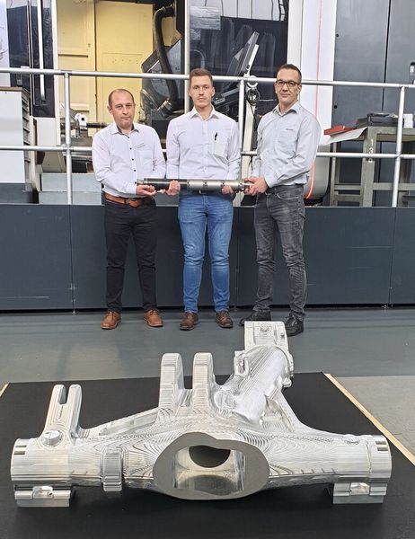 Partner in der Produktion der Flugzeugfahrwerke (v.l.) Konstantin Schäfer (Heggemann),  Kevin Richstein (Ingersoll) und Herbert Cappeller (Meissner) mit dem langen Werkzeug. Im Vordergrund das Bauteil. (Bild: Ingersoll)