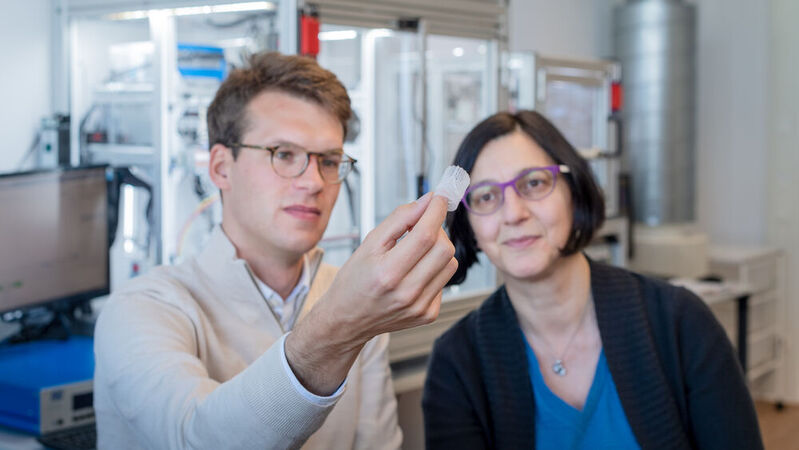 Prof. Dr. Petra Mela und Kilian Müller, M.Sc. Lehrstuhl für medizintechnische Materialien und Implantate, betrachten ein 3D-Herzklappen-Scaffold vor einer Melt-Electrowriting-Anlage.