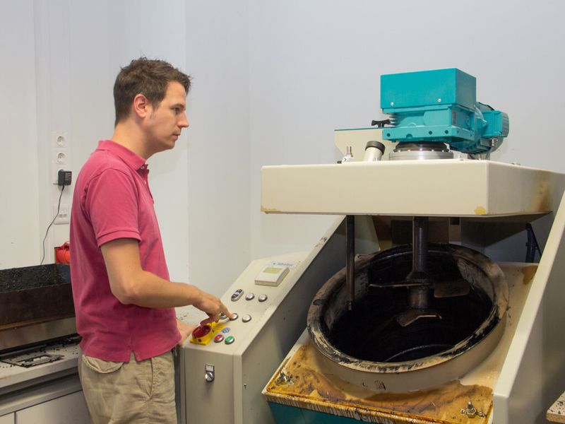 Bernhard Hofko mit der Prüfmaschine, mit der die Kälteeigenschafen von Asphalt bestimmt werden. (Bild: TU Wien)