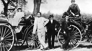 Carl Benz mit Familie und Baron Theodor von Liebieg im Jahre 1894, mit Benz Victoria und Benz Patent-Motorwagen Vis-à-Vis. Der Benz Victoria war das erste vierrädrige Fahrzeug von Carl Benz. (Daimler)
