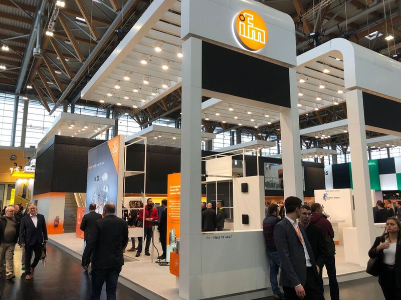 Sensorikspezialist IFM zeigte am gewohnt orangefarbenen Messestand neben zahlreichen Sensoren auch eine IIoT-Plattform, die unter dem Namen Moneo läuft. Deren Aufgabe soll es naturgemäß sein, aus Werten und Signalen der im Feld befindlichen Sensoren nutzbare Informationen und Handlungsempfehlungen zu generieren. Unternehmen sollen so zum Beispiel den bestmöglichen Wechselzeitpunkt von Werkzeugaufsätzen oder Auskunft über den Zustand von Motoren erhalten. (Bild: Vogel Communications Group)