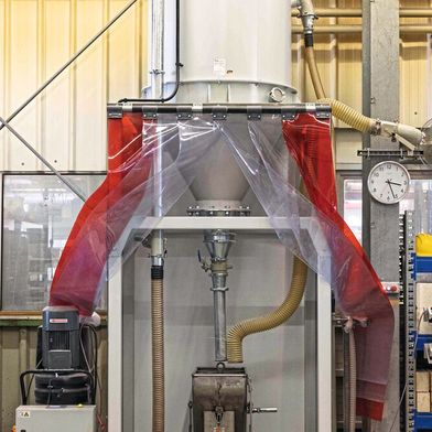 So transportiert man schonend: Das Saugaggregat (links) fördert die Korund-Flakes aus einem Bunker im Keller in das Silo (oben).  Unten in der Mitte ist der Transportwagen zu sehen. (Bild: Comet)