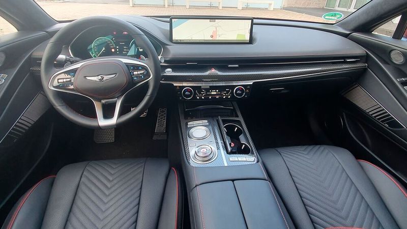 Der Innenraum: korrespondiert perfekt zum Außendesign. Genesis hat ein sehr hochwertiges und stimmiges Innenraumambiente mit viel Leder und Oberflächen mit Carbon-Optik geschaffen. Das Cockpit ist fahrerorientiert und wirkt sehr aufgeräumt. Bis auf die Klimatisierung, die sich über Tasten und einen Drehregler regeln lässt, werden alle anderen Funktionen über das langgezogene 14,5 Zoll große Infotainment-System gesteuert. (Bild: Mauritz – »kfz-betrieb«)