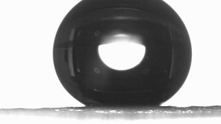 Wassertropfen (schwarz) über einem hydrophoben Partikel (grauer Bereich unten) (Bild: Helmholtz Institut/Ahn, Sohyun)