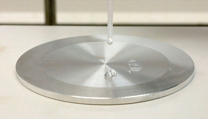 Leidenfrost effect makes water droplets on a hot plate hover over the surface instead of making physical contact with it. (Mikko Raskinen/Aalto University)