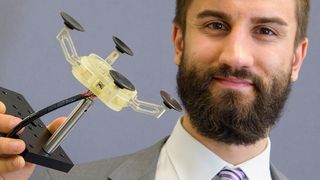 Ein neuartiger Saug-Greifer für flache Werkstücke wie Bleche oder Glasscheiben ist mit seinen Muskeln aus haarfeinen Formgedächtnisdrähten überaus gelenkig: Er lässt sich während des Betriebes umprogrammieren und passt sich dem Werkstück je nach Bedarf an. Ingenieur Paul Motzki aus dem Forscherteam von Professor Stefan Seelecke hat den Prototyp des Saug-Greifers mitentwickelt. (Bild: Universität des Saarlands / Oliver Dietze)