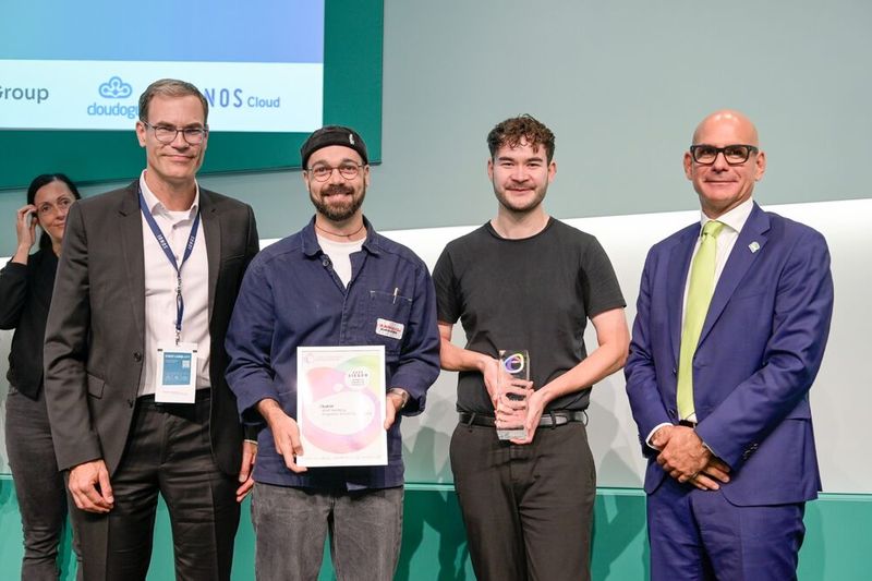 Die Jurymitglieder Dr. Markus Noga, CTO der IONOS SE (l.), und Holger Pfister, VP SUSE DACH (r.), überreichen den Preis in der Kategorie „Künstliche Intelligenz“ an die Stadt Bamberg. (Bild: Simon Salzig)