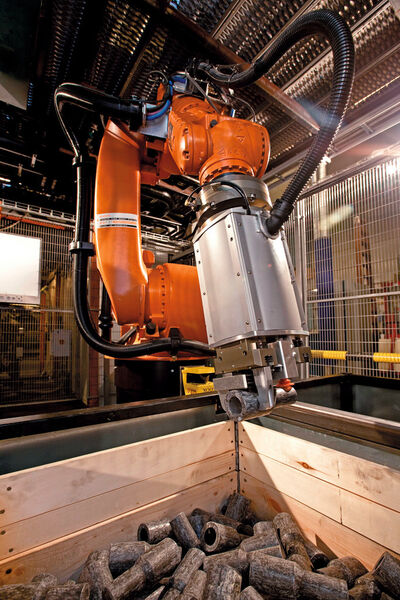 Bild 1: In der Roboterzelle werden die Metallzylinder aus der Kiste entnommen und einer Kaltfließpresse zugeführt. (Bild: Scape Technologies)
