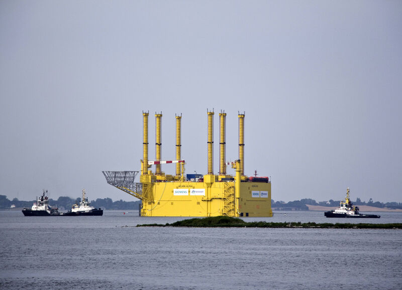 Drei Schlepper sind nötig um die 11.000 Tonnen schwere Konverterplattform vor die Küste Helgolands zu ziehen. Da der Stahlkoloss zu groß für den Nord-Ostsee-Kanal ist, wurde er um die Nordspitze Dänemarks herumgeschleppt. Nach sieben Tagen auf See und 990 zurückgelegten Kilometern hat HelWin1 nun ihren Installationsort erreicht. (Siemens/next step Filmproduktion)