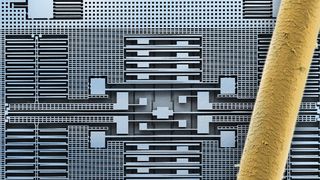 Bausteine für die vernetzte Welt: Das Bild eines Rasterelektronenmikroskops (REM) zeigt die feinen geätzten Silizium-Strukturen eines Beschleunigungssensors von Bosch. Zum Größenvergleich liegt ein menschliches Haar auf der Struktur. Die Silizium-Strukturen in der Mitte des Chips messen die Beschleunigung oder Neigung in allen drei Raumrichtungen. Die einzelnen „Balken“ sind rund 2 µm breit und 20 µm hoch. Das Haar ist im Vergleich rund 90 µm dick. (Bild: Robert Bosch GmbH)