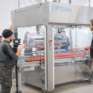 Projektleiter Jochen Weller von Optima Consumer (rechts im Bild) kommuniziert mit dem Kunden und erläutert die Vorgänge im Inneren der Maschine.(Bild:  Optima)