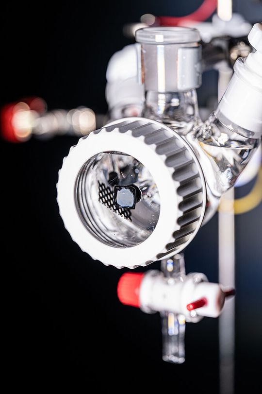 Die photoelektrochemische Schlenk-Zelle im Sonnensimulator. Die rechteckige, graue Fläche mit schwarzer Einrahmung im Vordergrund ist die photoelektrochemische Solarzelle. (Bild:  Valentin Marquardt / Universität Tübingen)