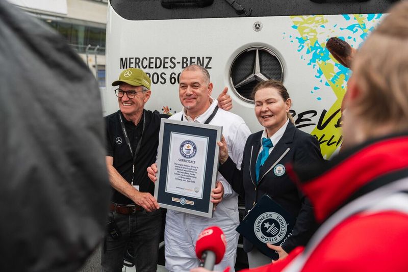 Guinnes-World-Record-Titel für die längste rückwärtsgefahrene Strecke mit einem Sattelzug (Einzelperson) geholt. Marco Hellgrewe (Mitte) und Werner Kempfle, Entwicklungsingenieur und Co-Projektleiter des eActros 600, nehmen die Auszeichnung von Seyda Subasi-Gemici, Jurorin, Guinness World Records Limited, entgegen. (Bild: © Daimler Truck AG)