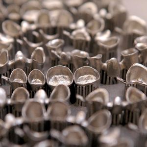 Bild 1 | Generative Fertigung: Mittels Direktem Metall-Laser-Sintern (DMLS) „wachsen“ automatisch vollständige 3D-Zahnersatzlösungen heran (hier noch mit Stützstrukturen).