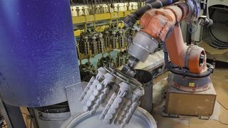 Die Modelltraube mit Wachsmodellen wird vom Roboter in den sogenannten Schlicker getaucht.  (Bild: Kuka)