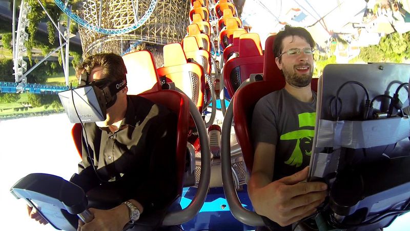 Prof. Thomas Wagner (links) und der Lehrbeauftragte Michael Heyse (rechts) rasen mit Laptop und VR-Brille durch den Looping der Achterbahn „Blue Fire“. (FH Kaiserslautern)