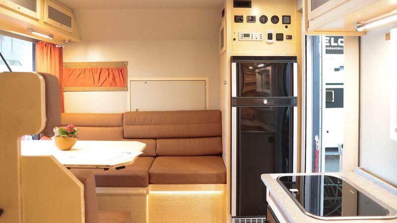 Der Technik-Tower direkt am Eingang beinhaltet unter anderem einen Kühlschrank. Die sich daran anschließende Sitzgruppe lässt sich optional mit einem Panoramafenster in einen Hochsitz mitten in der Natur verwandeln und ist in ein Doppelbett umbaubar. (Bild: Messe Düsseldorf/ctillmann)