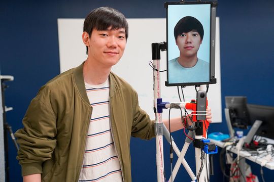 Mose Sakashita, a doctoral student in the field of information science, with the Remotion robot. Mose Sakashita, a doctoral student in the field of information science, with the Remotion robot.
