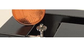 Im Vergleich mit einer Ein-Cent-Münze wird die Größenordnung der Prismenhalterung des Mikro-Reitstocks deutlich. (DK Fixiersysteme)