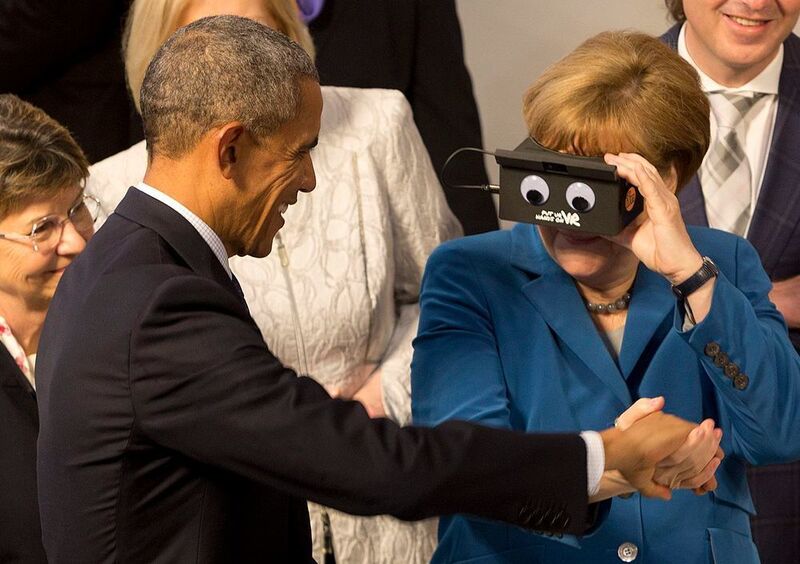 Ein symbolträchtiges Bild: Mit einer Virtual-Reality-Brille ausgestattet greift Bundeskanzlerin Angela Merkel nach einer Hand im digitalen Raum. US-Präsident Barack Obama nutzt die Gelegenheit und reicht ihr seine Hand in der realen Welt.  (Deutsche Messe/Gunnar Mitzner)