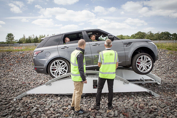 Ein Range Rover wird per Smartphone von außen im Schrittempo über ein Hindernis geführt. (Foto: Jaguar Land Rover)