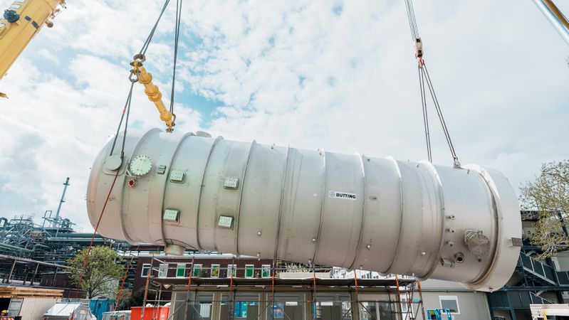Ein Schwergewicht: Zwei Kräne heben den fast 100 Tonnen wiegenden Fallfilmverdampfer in die Luft.(Bild:  BASF)