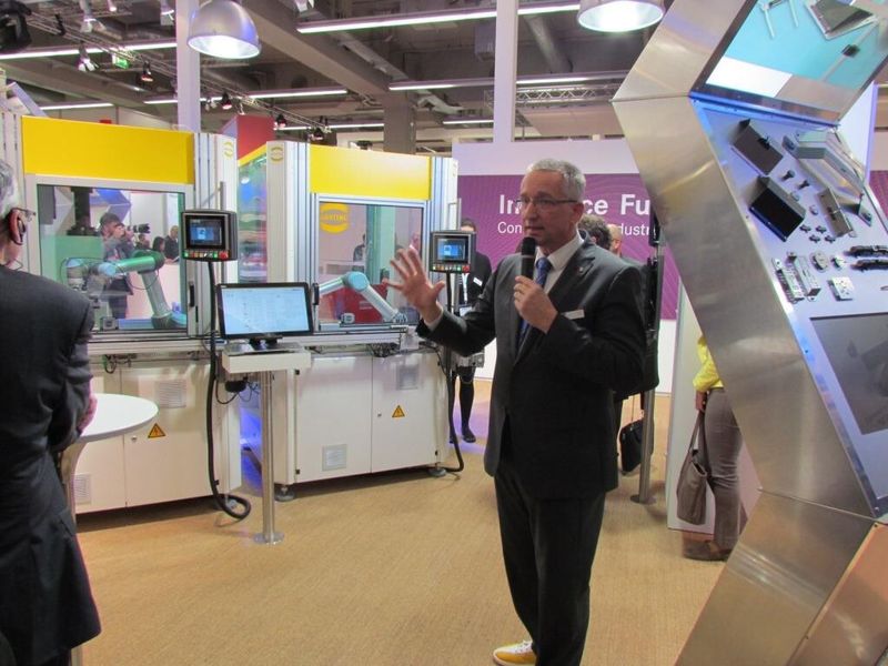 Dr. Volker Franke, Geschäftsführer Harting Applied Technologies erläutert auf der SPS IPC Drives 2014 den Forschungszweck der Fleximon-Anlage. Mit der Anlage sollen Lösungen zur Flexibilisierung von Fertigungsabläufen erforscht werden. (Bild: s. häuslein/konstruktionspraxis)