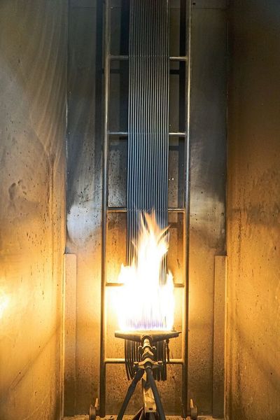Vertikale Flammtests im Bündel: Im Bild wird die Entﬂammbarkeit nichtmetallischer Bestandteile und die Brandfortleitung am Kabel getestet. (Lapp)