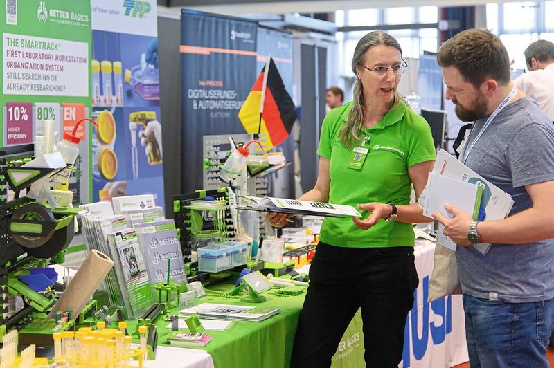 Immer in knalligem Grün unterwegs: Das Team von Better Basics, welches mit modularen Racks die Organisation des Laborarbeitsplatzes erleichtert.  Mehr Infos zu den kommenden LAB-SUPPLY-Messen finden Sie auf www.lab-supply.info (Bild: Stefan Stark)