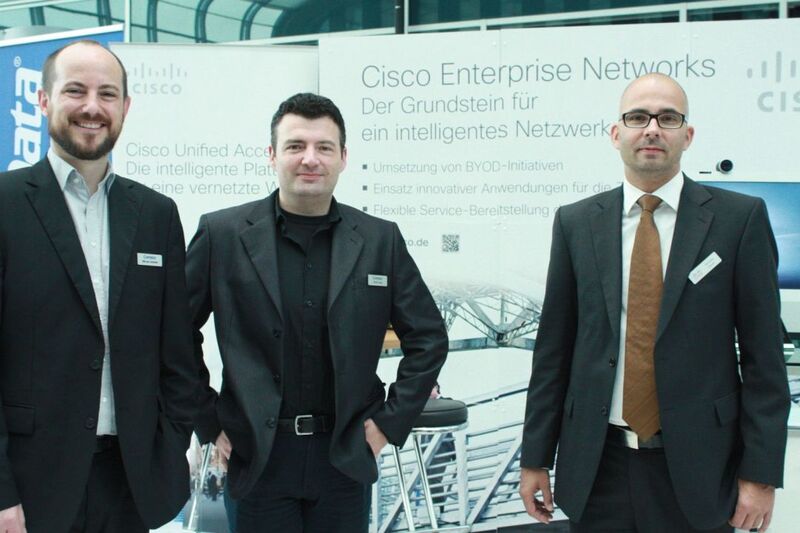 Stefan Seier und Marcus Schmidt von Comstor zusammen mit Christian Gauer von Cisco am Partnerstand.(v.l.) (Vogel IT-Medien)