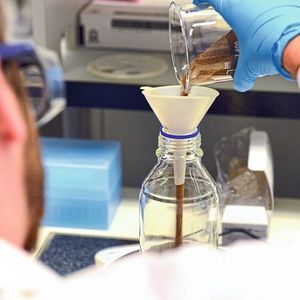 Ein ETH-Umweltforscher befüllt eine Flasche mit Erdmaterial und einem Stück PBAT-Folie, um deren biologischen Abbau unter kontrollierten Bedingungen untersuchen zu können.