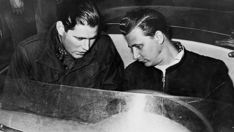 Herbert Linge, Hans Herrmann (v.l.) im Vorfeld der Mille Miglia 1954. Bei diesem Rennen macht der Schwabe durch eine spektakuläre Aktion auf sich aufmerksam: Als direkt vor ihm die Bahnschranken für den herannahenden Schnellzug nach Rom im letzten Moment geschlossen wurden, konnte er nicht mehr bremsen. Er und sein Beifahrer duckten sich in das Cockpit des flachen Porsche 550 Spyder, und der Wagen fuhr unter den Schranken gerade noch vor dem Zug hindurch. Das Ergebnis waren ein erneuter Klassensieg und der sechste Platz im Gesamtklassement.  (Bild: Porsche AG)