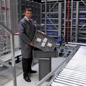 Dipl.-Wirtsch.-Ing. Jörg Reinelt, Logistikplanung Ersatzteile Porsche AG, zentrales Ersatzteillager Sachsenheim, zeigt ein Tablar mit vier aufgesteckten Fixierelementen.
