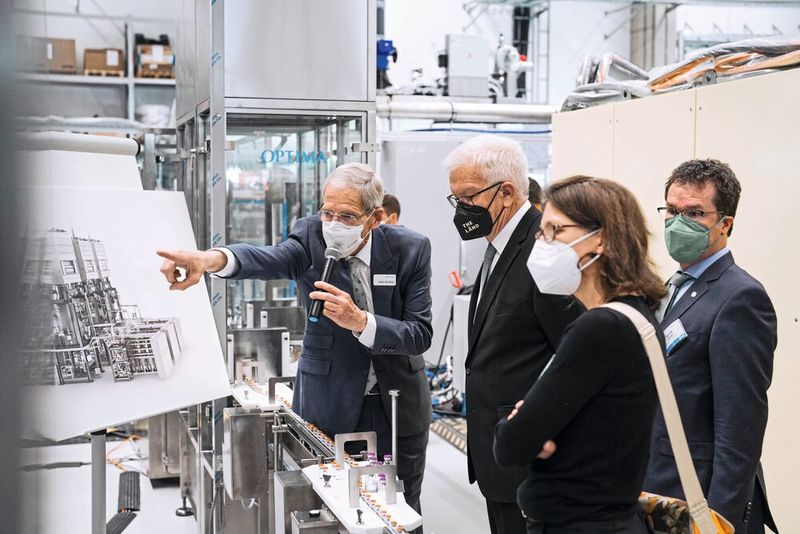 V. l.: Hans Bühler, Managing Director/CEO der Optima Gruppe, erläutert Baden-Württembergs Ministerpräsident Winfried Kretschmann, Jutta Niemann (MdL, Bündnis 90/Die Grünen) und Harald Ebner (MdB, Bündnis 90/Die Grünen) die Funktionsweise einer pharmazeutischen Abfüllanlage. Zahlreiche Anlagen wurden für die Abfüllung der Corona-Impfstoffe mit höchster Priorität bei kompromissloser Qualität an Kunden weltweit ausgeliefert.  (Bild: Optima)