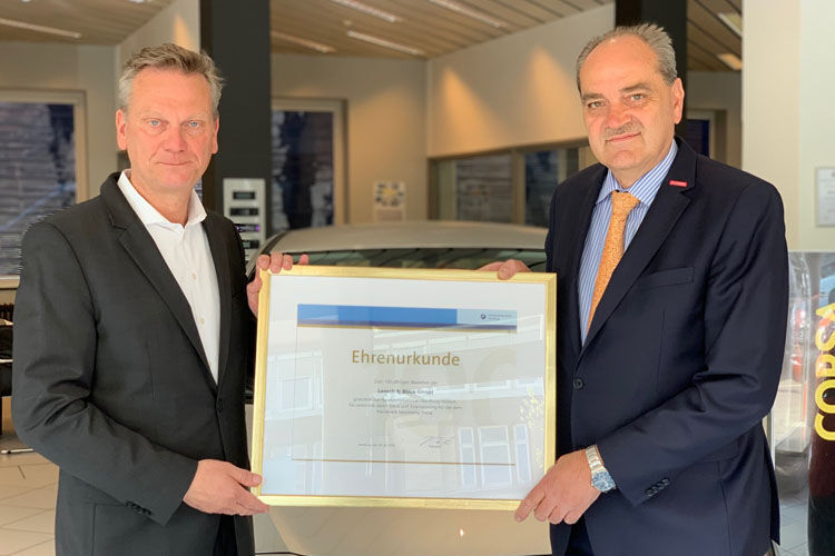 Arne Joswig (l.), Geschäftsführer des Autohauses Lensch & Bleck, erhält von Martin Hildebrandt, Vorstandsmitglied der Handwerkskammer Hamburg, eine Auszeichnung für das 100-jährige Jubiläum seines Betriebs. (Lensch & Bleck GmbH)