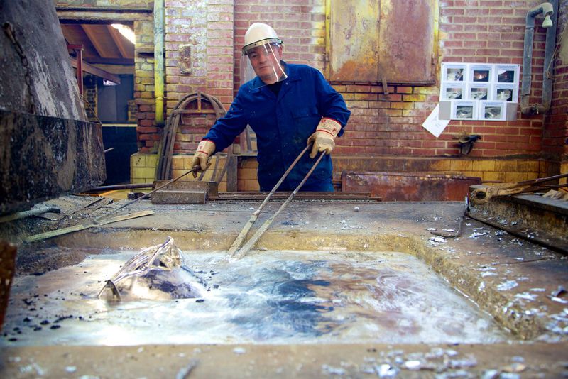 Der sogenannte zieht den Eimer, der jetzt wie poliertes Silber glänzt, nach einigen Drehbewegungen aus dem flüssigen, 465 Grad heißen Metall und taucht ihn in ein Wasserbecken. (Bild: Gesamtmetall/Pit Junker)