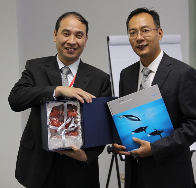 Zum Zeichen der engen Beziehungen tauschen Victor Chen, Chef des Supply Chain Managements bei ABB Robotics China (rechts) und Tang Yi, Leiter der Fabrikautomation im Industrie-Segment Gast-Geschenke aus. Festo hatte kurz zuvor einen Lieferanten-Qualitätspreis gewonnen. (Jablonski)