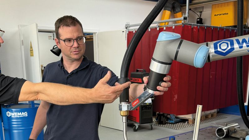WEMAG-Geschäftsführer Christopher Schaus präsentiert einen Cobot(Quelle:  WEMAG GmbH & Co. KG)