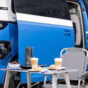 Außerdem gibt es Verdunklungselemente für alle Scheiben, Lüftungsgitter für die vorderen Seitenfenster sowie zwei Campingstühle und einen Campingtisch für draußen.(Bild:  VW)